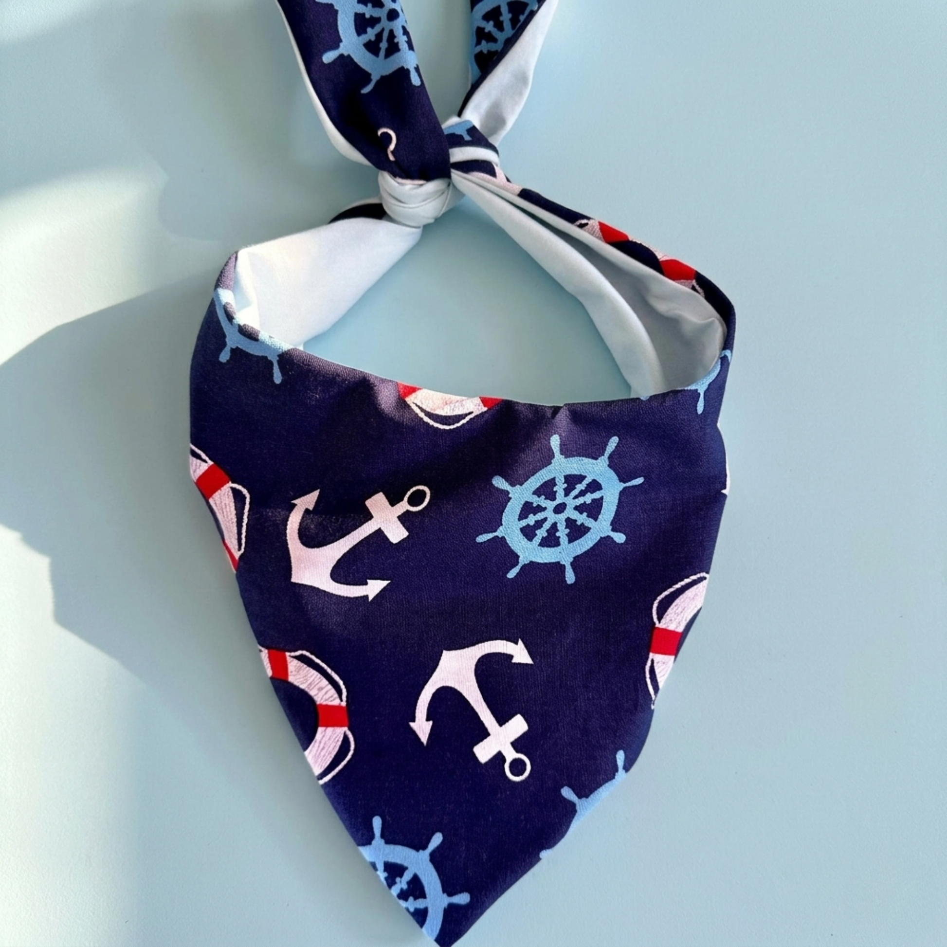 Nautical-themed bandana with anchors and ship wheels on a light blue background